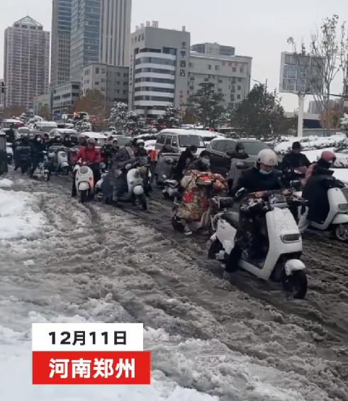 河南市民骑电动车在雪地里艰难前行：调侃12月11日成为了郑州全民迟到日 ！-第1张图片